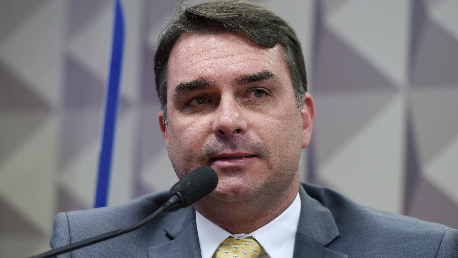 O senador Flávio Bolsonaro fala ao microfone durante reunião de comissão do Senado