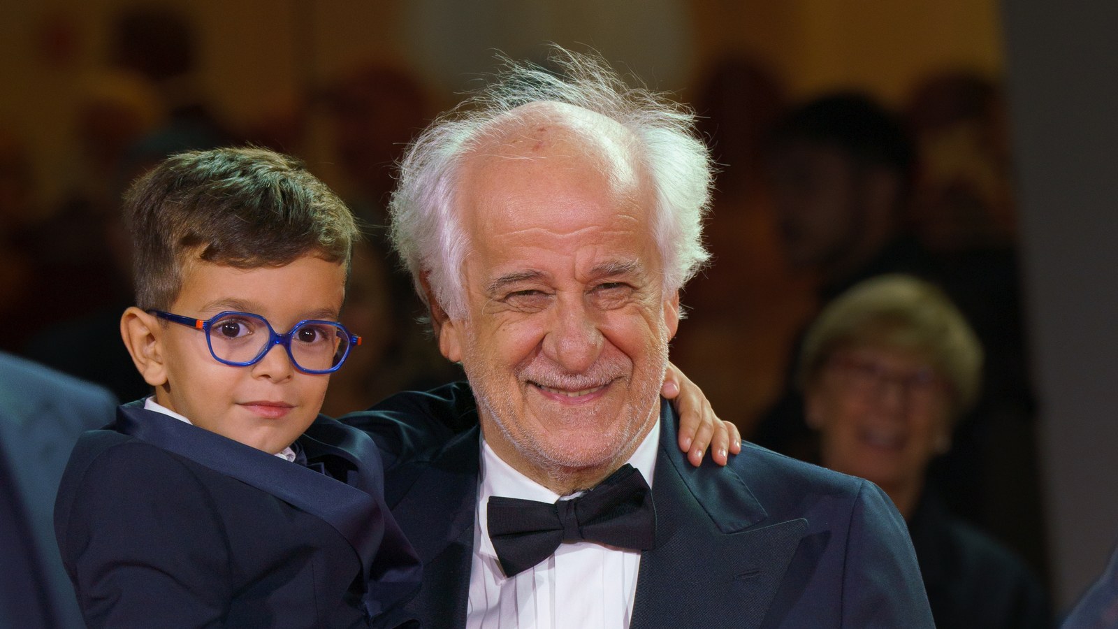 Toni Servillo segura o menino Lorenzo Perrotta no colo durante o Festival de Cinema de Veneza