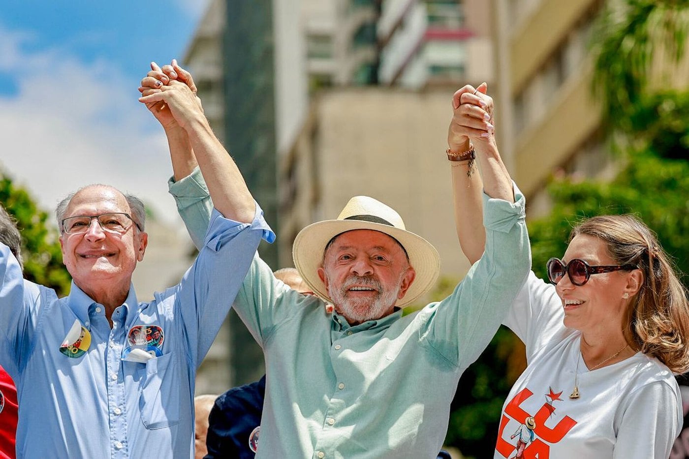 Lula, de chapéu, e Geraldo Alckmin, de camisa azul, erguem as mãos dadas ao lado de Janja em ato de campanha na Avenida Paulista