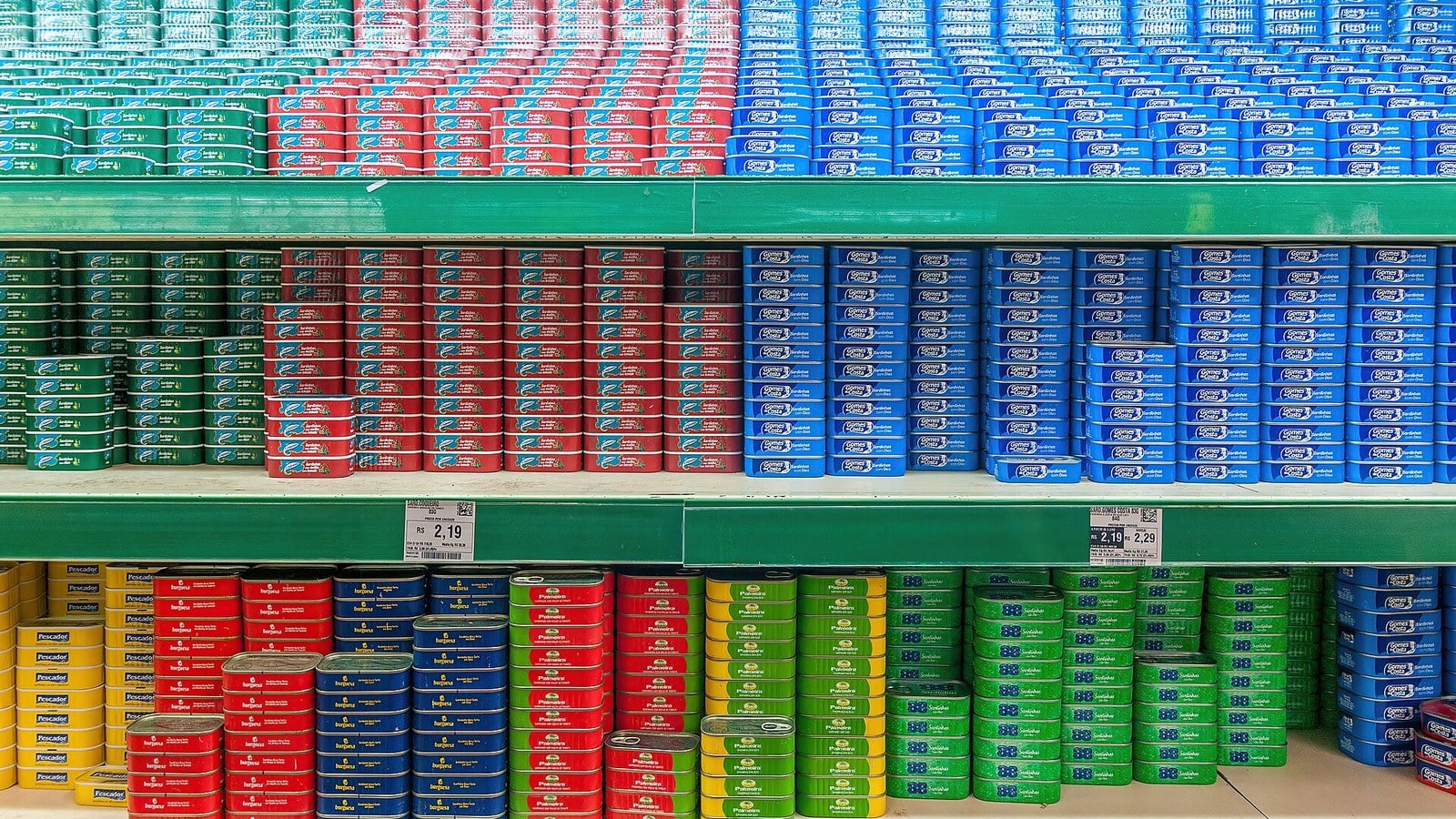 Prateleira de supermercado com latas de conserva e etiquetas de preço