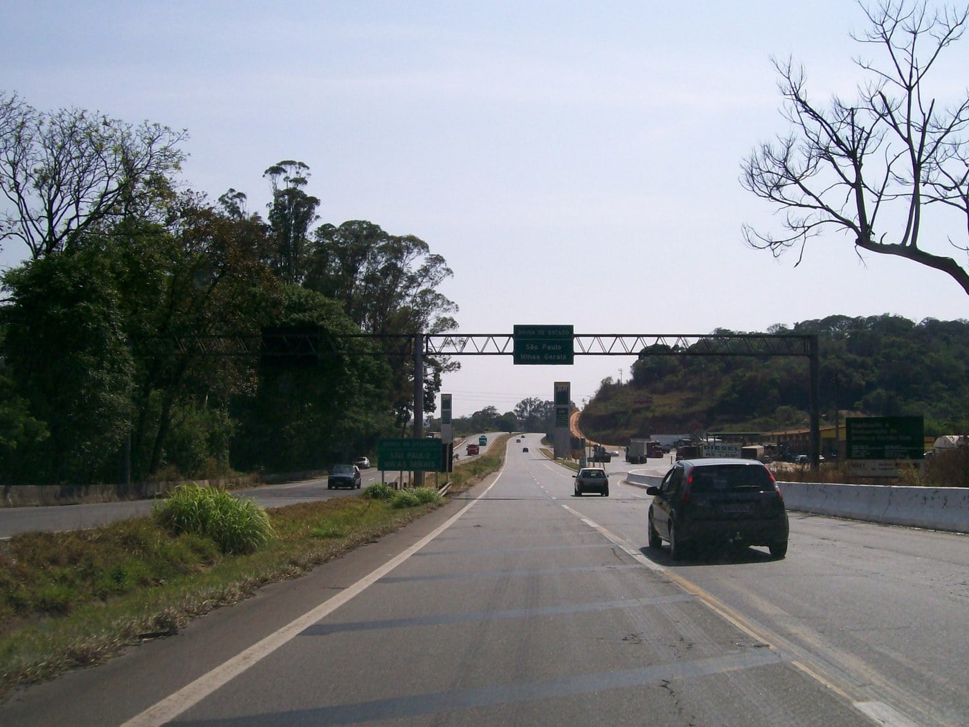 Pista dupla da Rodovia Fernão Dias com carros e caminhões e placa indicando Belo Horizonte e São Paulo