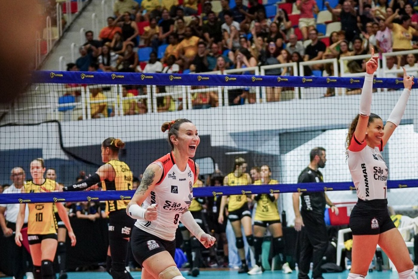 A atleta Tifanny Abreu, de uniforme branco do Osasco, comemora em quadra