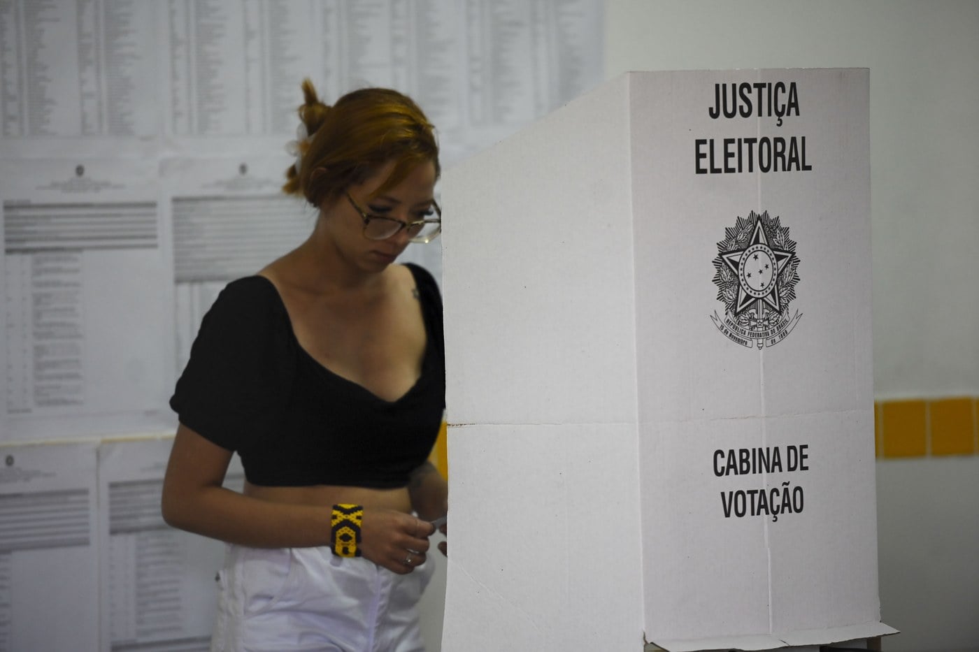 Eleitora em frente à urna eletrônica em uma seção eleitoral