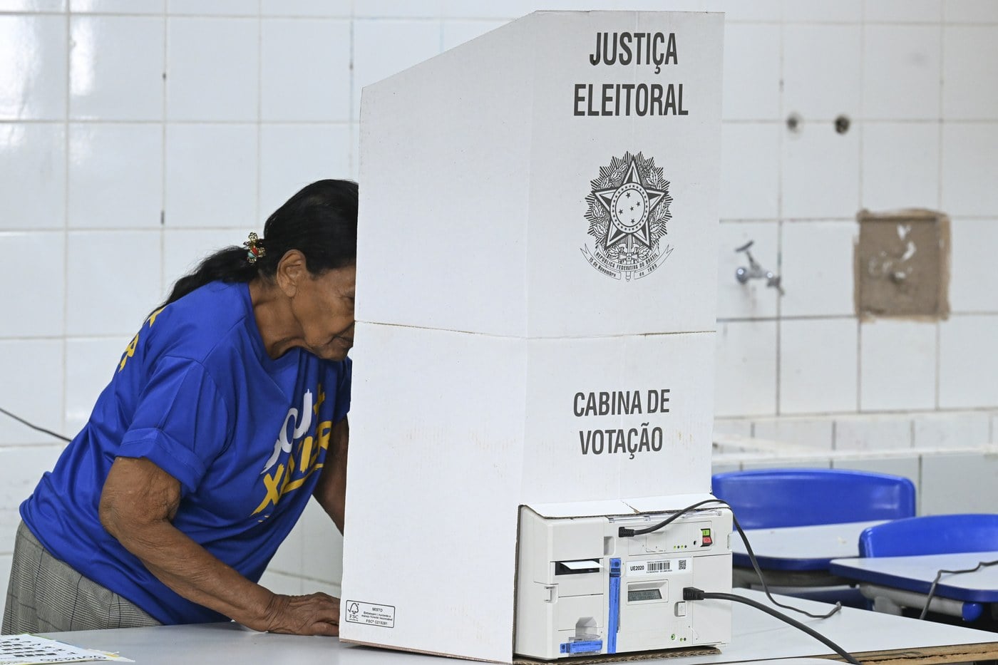 Eleitora em frente à urna eletrônica em uma seção eleitoral